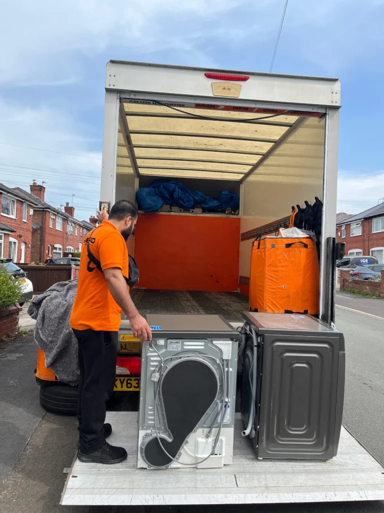 A Metro Man and van team member securing a fridge freezer with professional removal blankets, a key step in a safe Manchester appliance move.
